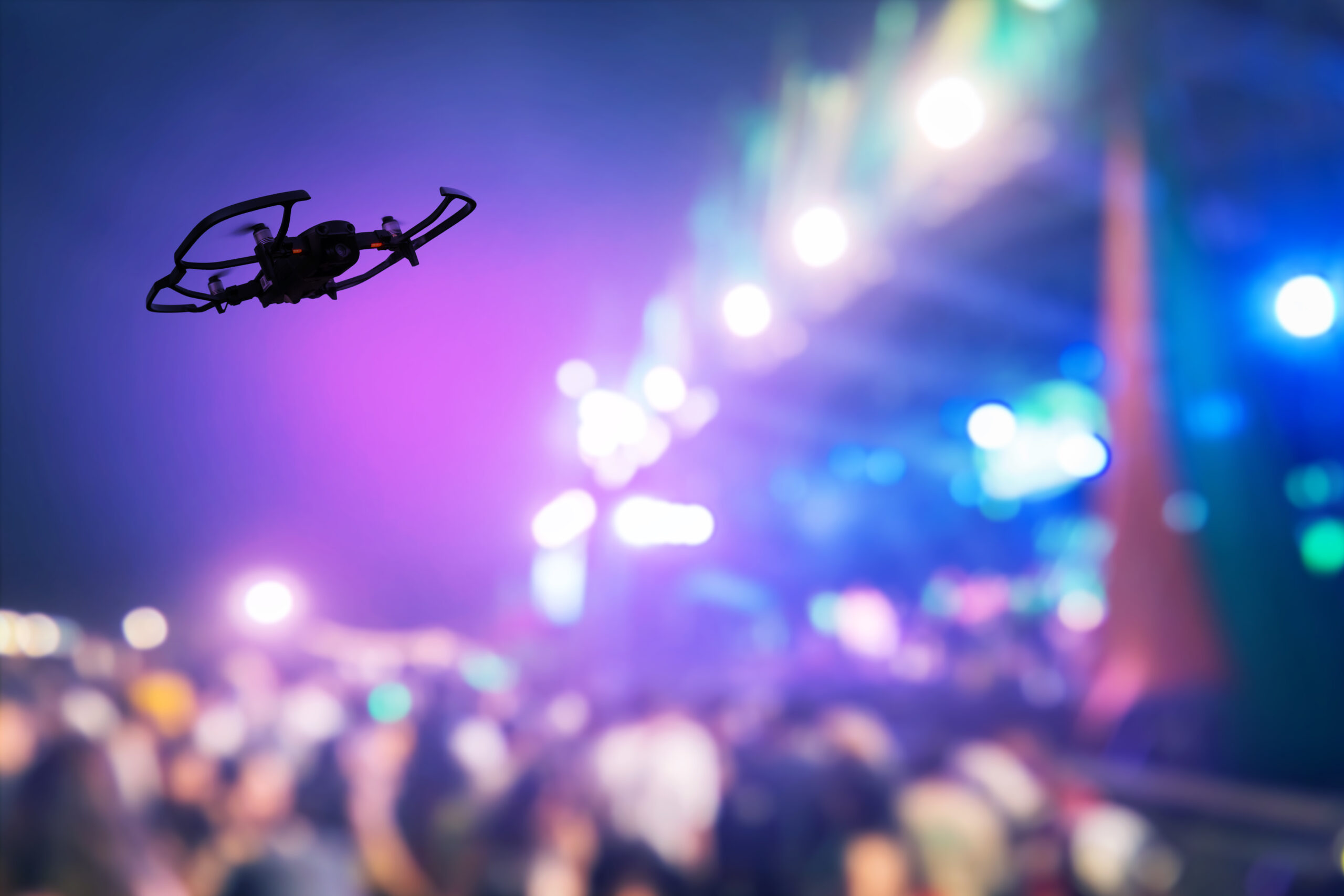 Silhouette of Drone flying for taking video streaming in outdoor concert stage